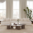 Ivory boucle sofa and sculptural oak coffee tables in a bright loft with tall windows